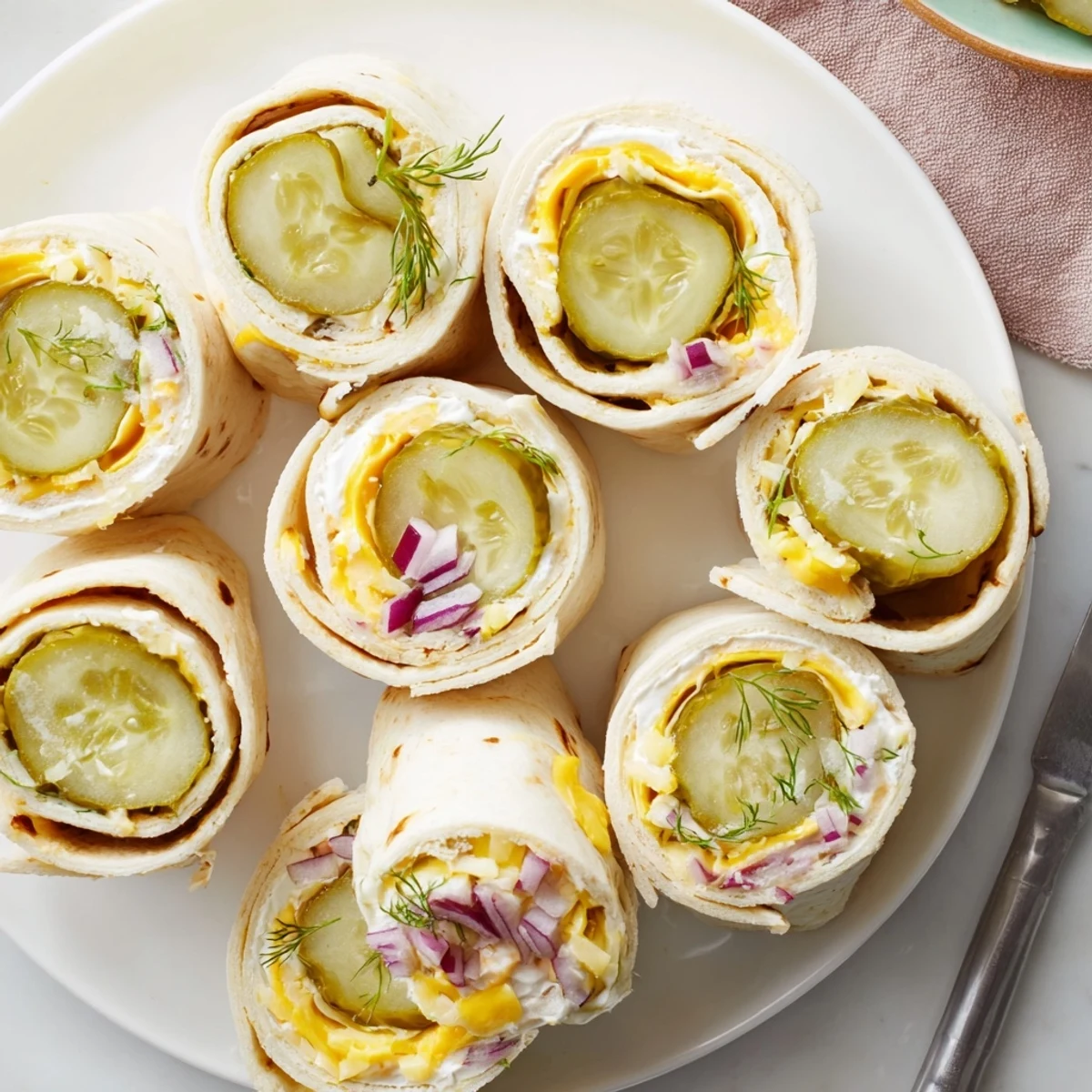 Tangy pickle-in-a-blanket sliced and served chilled for a refreshing appetizer experience.