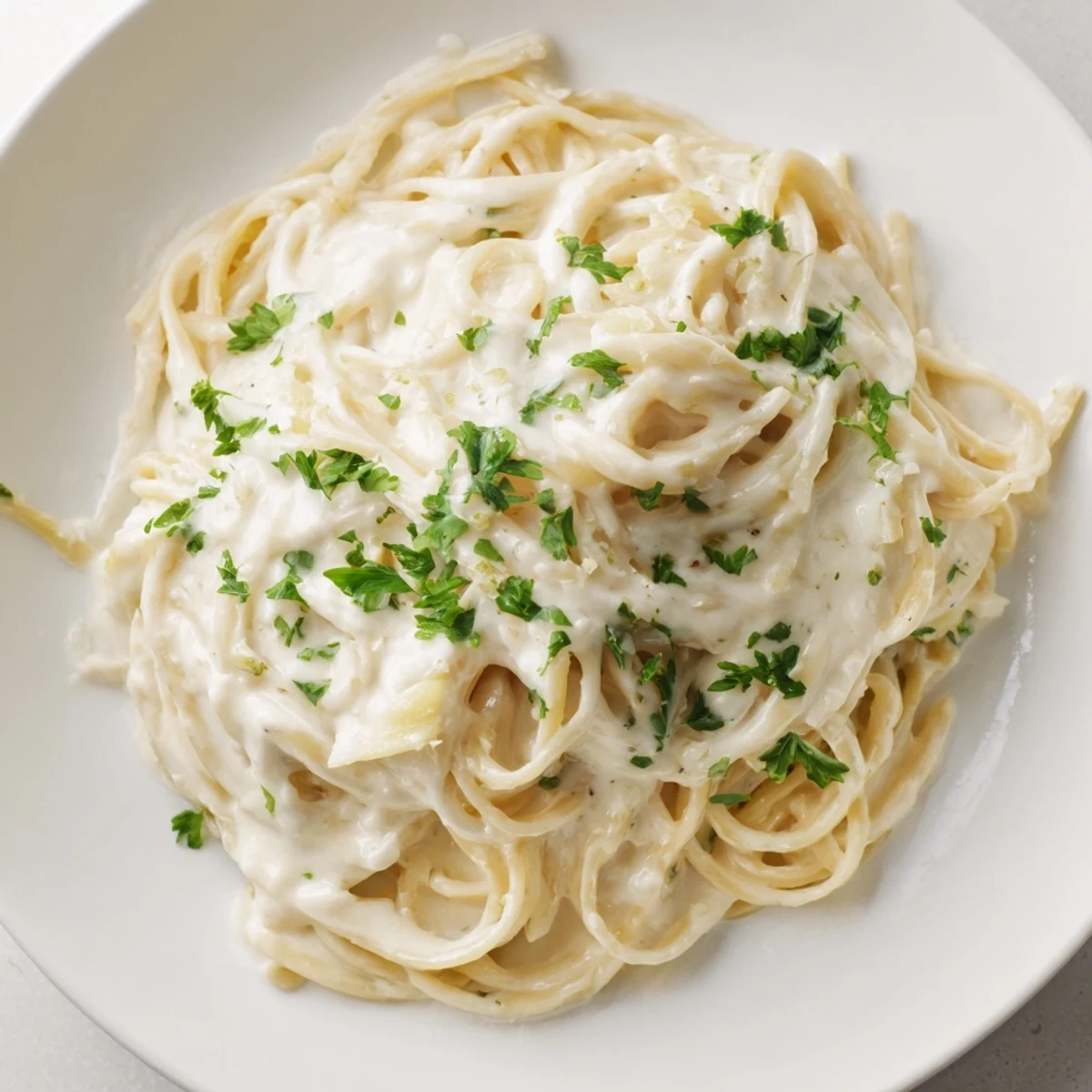 This photo shows a creamy three-cheese spaghetti dish, perfectly tossed with melted, golden cheeses and pasta.