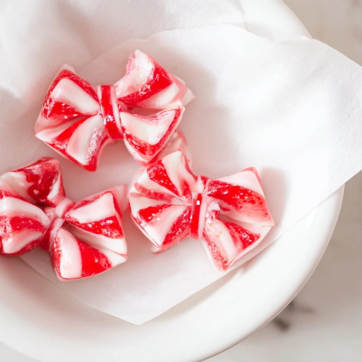 Hot, melty Express Peppermint Candy Bows shimmering with edible glitter, ready for gifting or holiday treats.