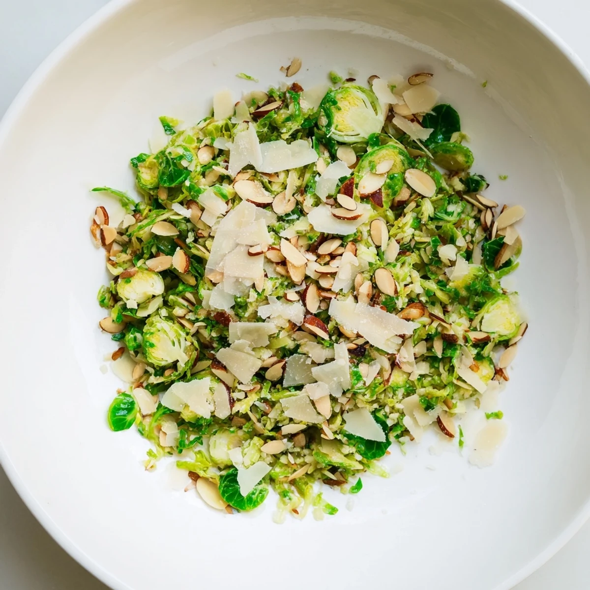 Freshly tossed Crunchy Lemon Parmesan Brussels Sprouts Salad, featuring crunchy almonds and vibrant lemon.