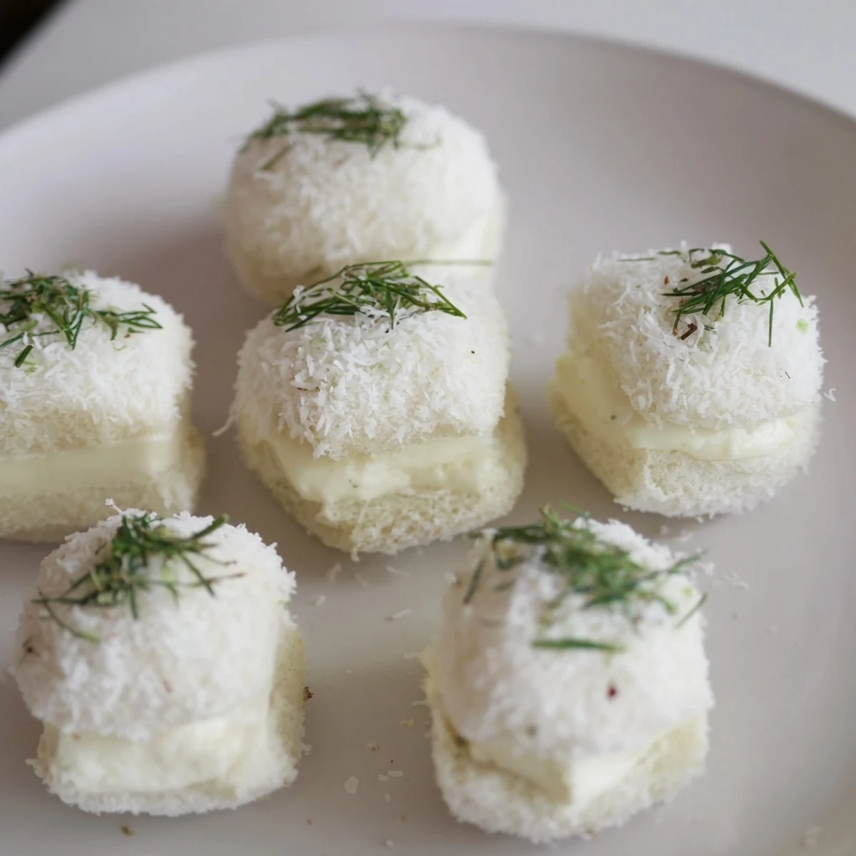 Fluffy Snowball Tea Sandwich Bites, rolled in coconut, perfect for afternoon tea spreads or winter parties.