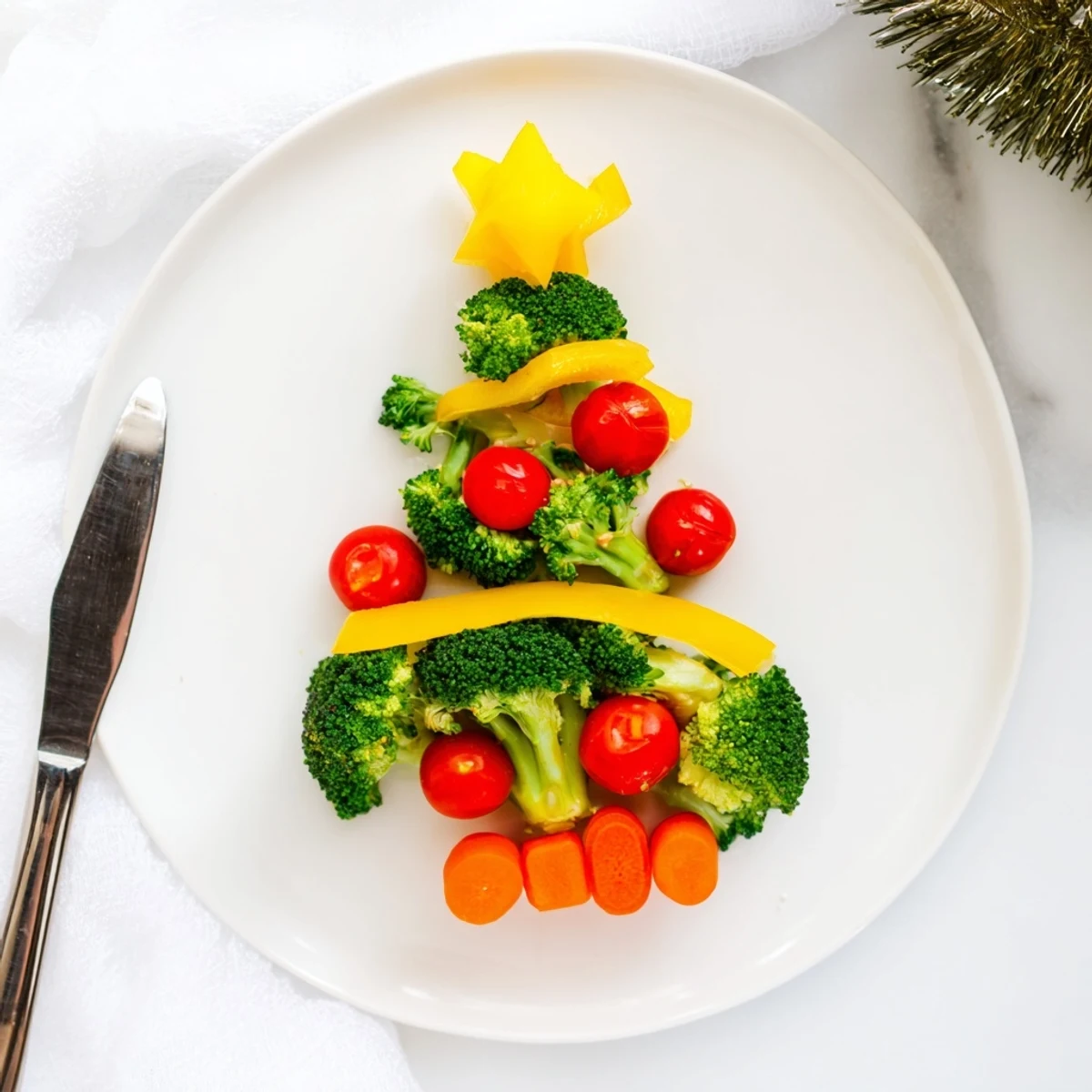 Festive broccoli tree with cherry tomato ornaments, a healthy and colorful appetizer for your party.
