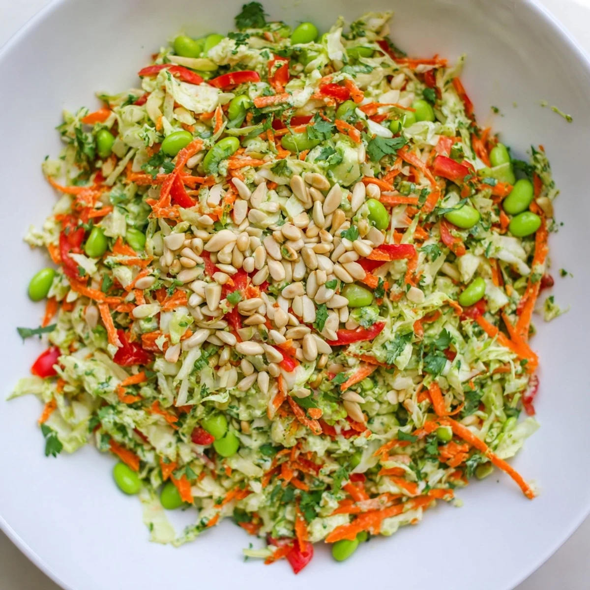 Bright, colorful Crunchy Cabbage and Edamame Salad topped with toasted almonds and sunflower seeds, ready to enjoy.