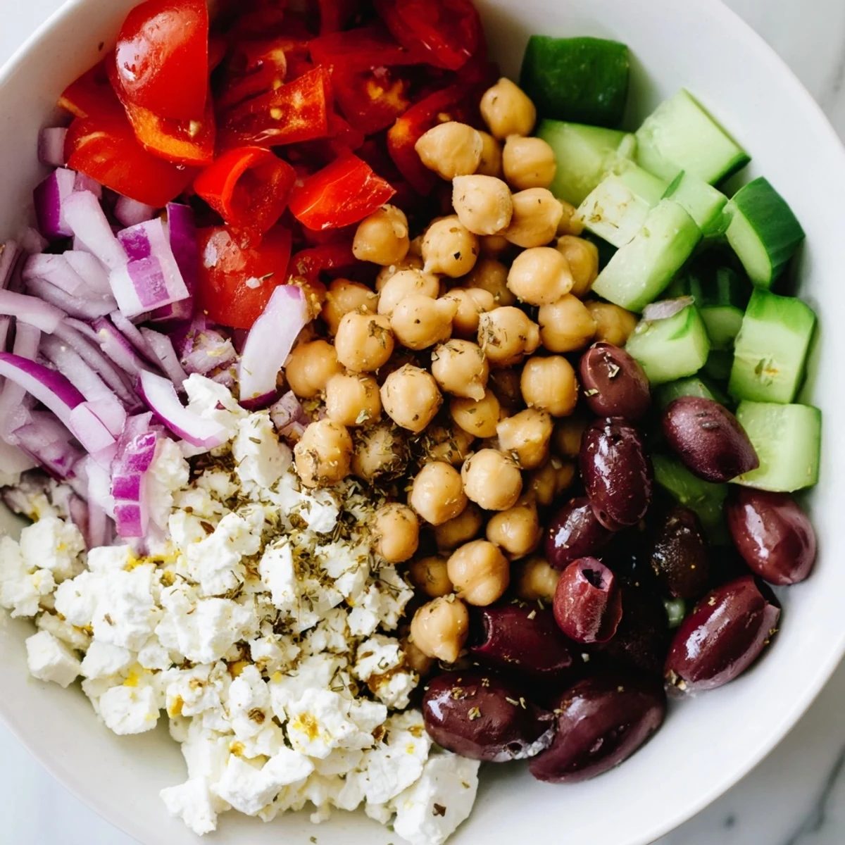 Mediterranean Chickpea and Feta Bowl, a vibrant vegan delight, showcasing fresh vegetables and crumbled feta.