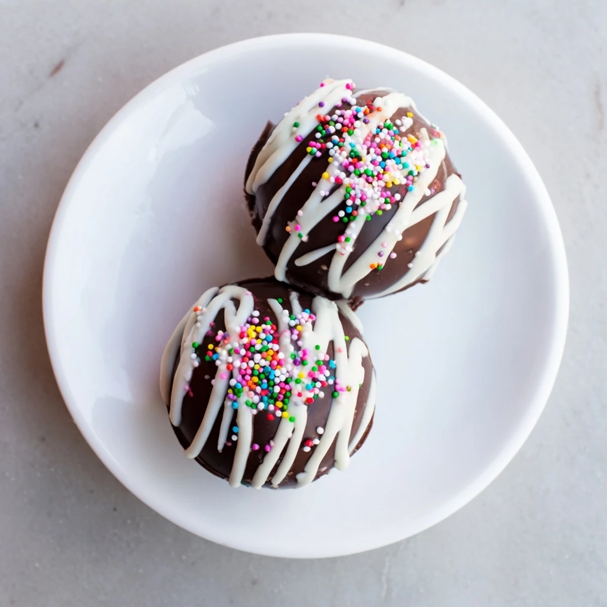 A mug of rich, creamy hot chocolate with a melting bomb inside, showing fluffy marshmallows rising as the chocolate swirls into the warm milk.