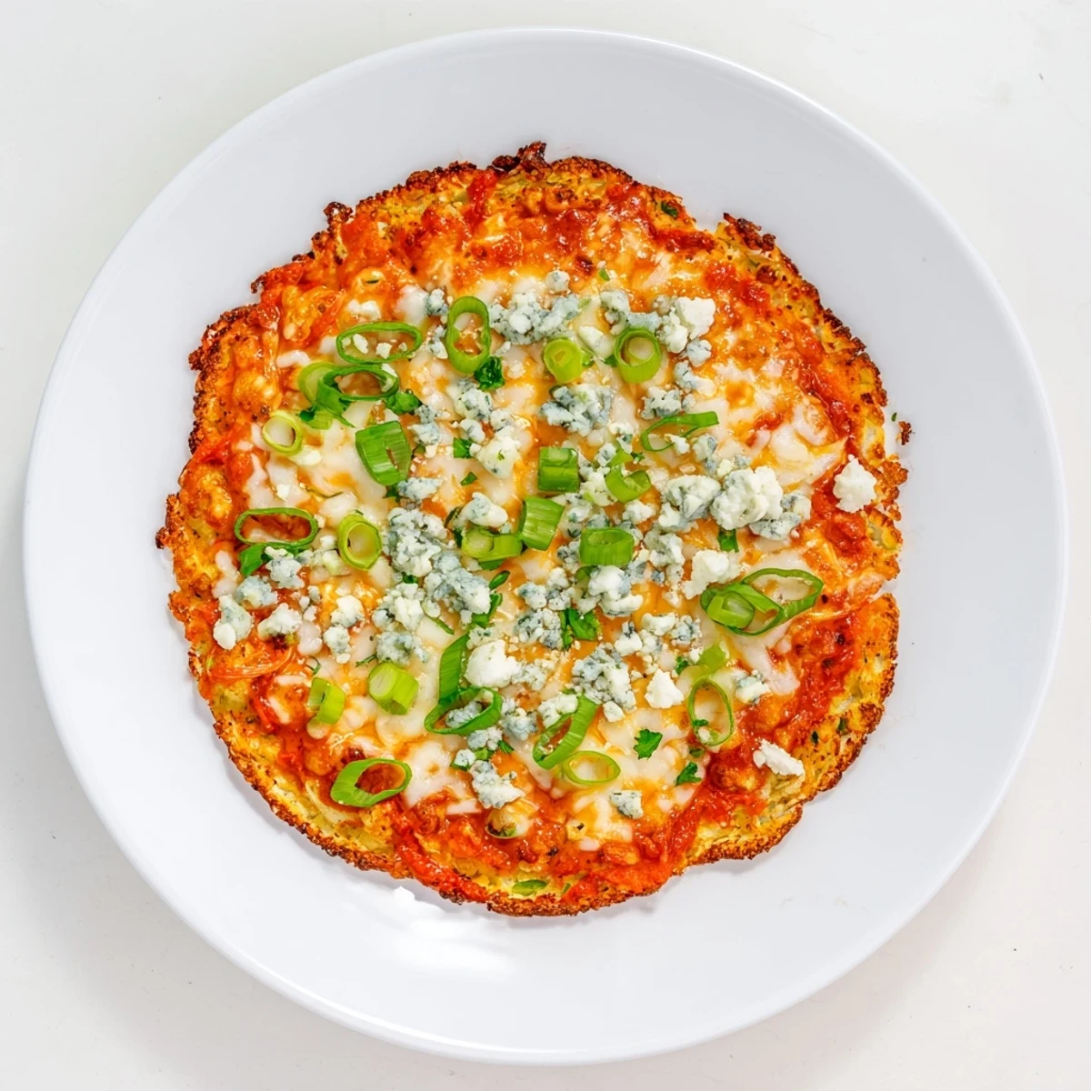 Golden, bubbly mozzarella blankets a crispy cauliflower crust brushed with tangy buffalo sauce, topped with fresh green onions.  