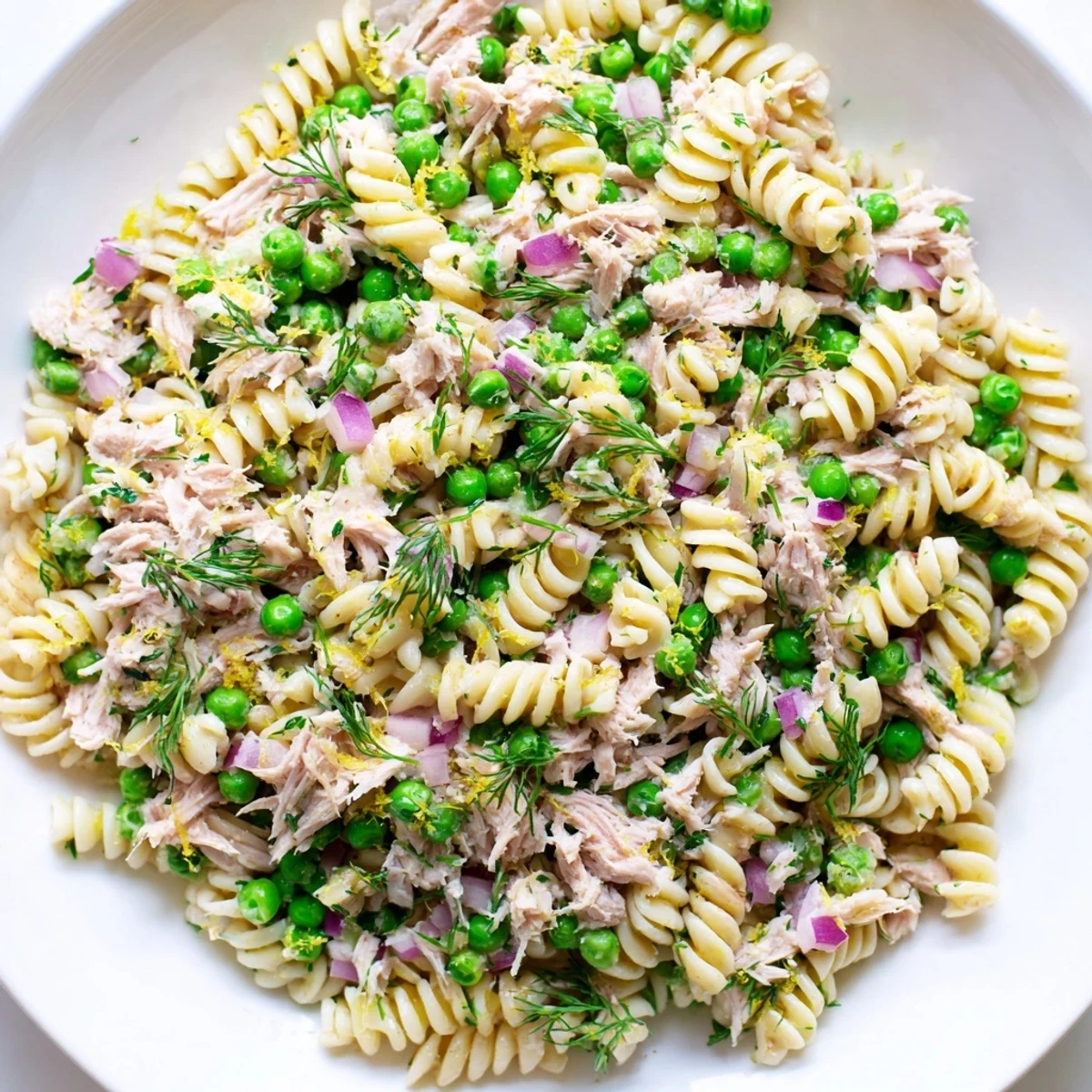 Perfect for picnics, this chilled Lemony Tuna Pasta Salad combines savory tuna with al dente pasta and a tangy lemon-herb dressing.