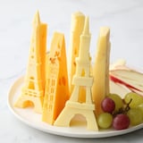 Visually stunning Skyline Silhouette cheese board offering architectural cheese shapes with fruit and crackers.