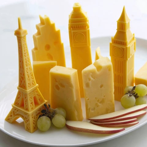 A vibrant Skyline Silhouette cheese platter, with cheddar buildings, grapes, and crackers for a snack.