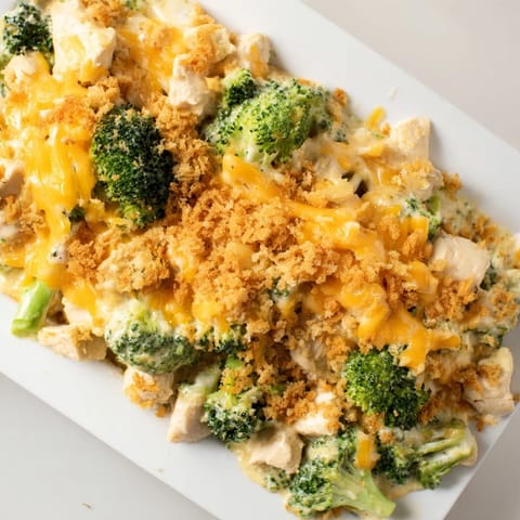 A close-up of a creamy Chicken & Broccoli Cheddar Bake with a crispy, golden topping.