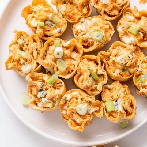 These baked Buffalo Chicken Dip Pinwheel Wontons boast a spicy, creamy filling, perfect for game day.