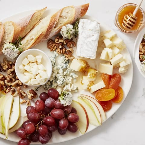 Delicious Honeycomb, Honey, & Cheese Board with Brie, grapes, and nuts, perfect for sharing and easy to make.