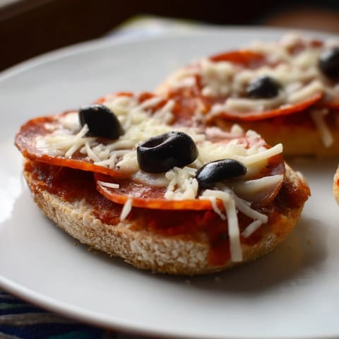 Santa Belt Mini Pizza Bites, mini pizzas with pepperoni belts and olive buckles, ready for a festive holiday treat.