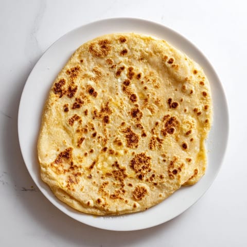 Homemade cottage cheese flatbread, warm from the skillet, offering a tempting aroma of baking bread.