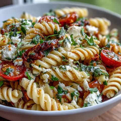 Colorful pasta salad with cherry tomatoes, crisp cucumbers, and zesty Italian dressing, perfect for summer picnics and gatherings.