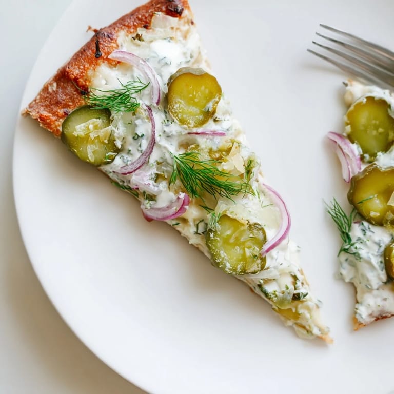 Sizzling hot pickle pizza emerges from the oven, bursting with tangy crème fraîche flavor.  
