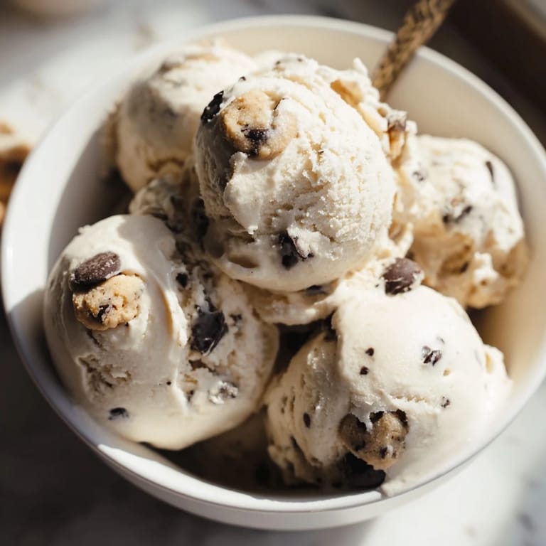 A delightful bowl of cottage cheese ice cream, swirled with sweet cookie dough bites.  