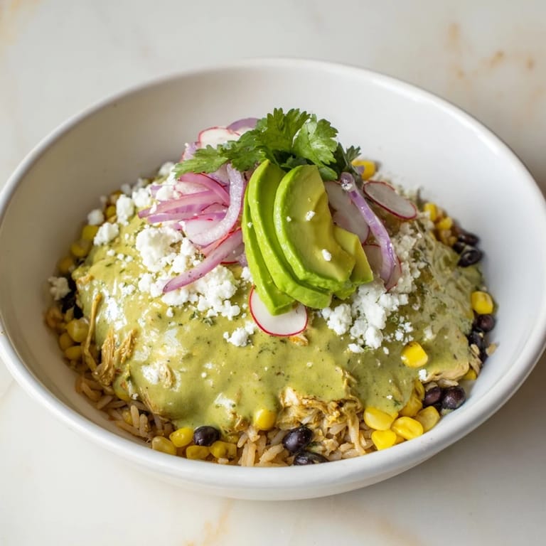A close-up of a delicious Green Enchilada Rice Bowl, featuring savory chicken and colorful toppings, perfect for lunch.