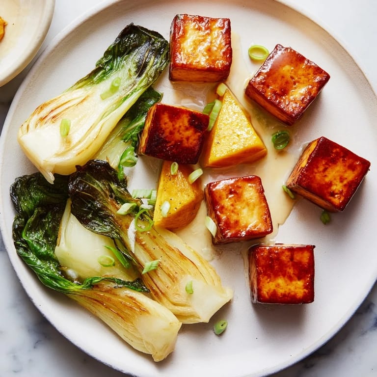 Vibrant photo showing caramelized miso-glazed tofu with roasted squash and a side of bok choy.
