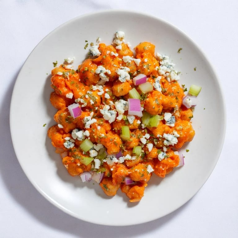 This colorful buffalo chicken bean salad features juicy chickpeas, crunchy vegetables, and zesty sauce.