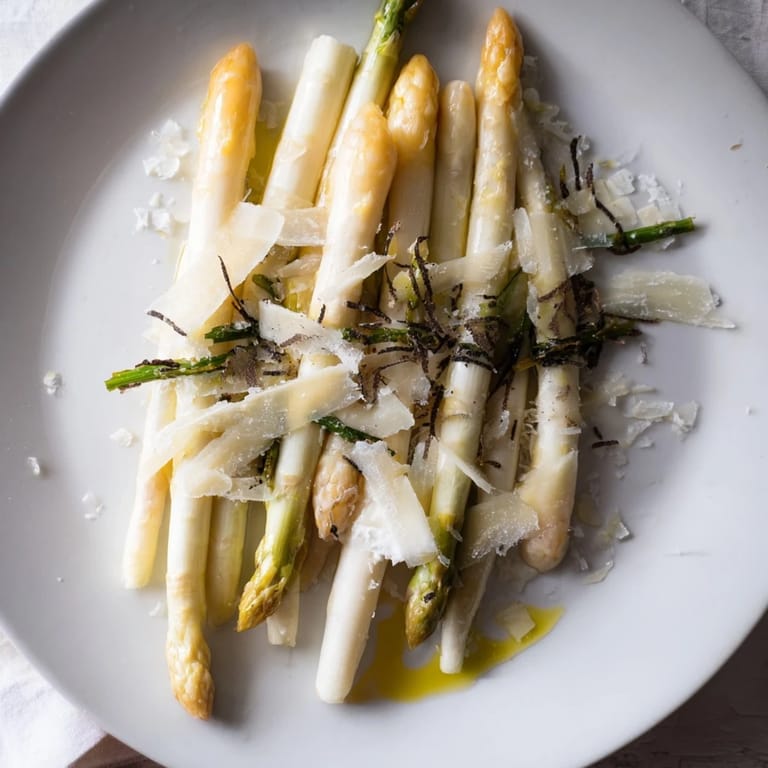 A gourmet plated The Silver Birch starter showcasing vibrant asparagus, creamy burrata, and earthy truffle shavings.