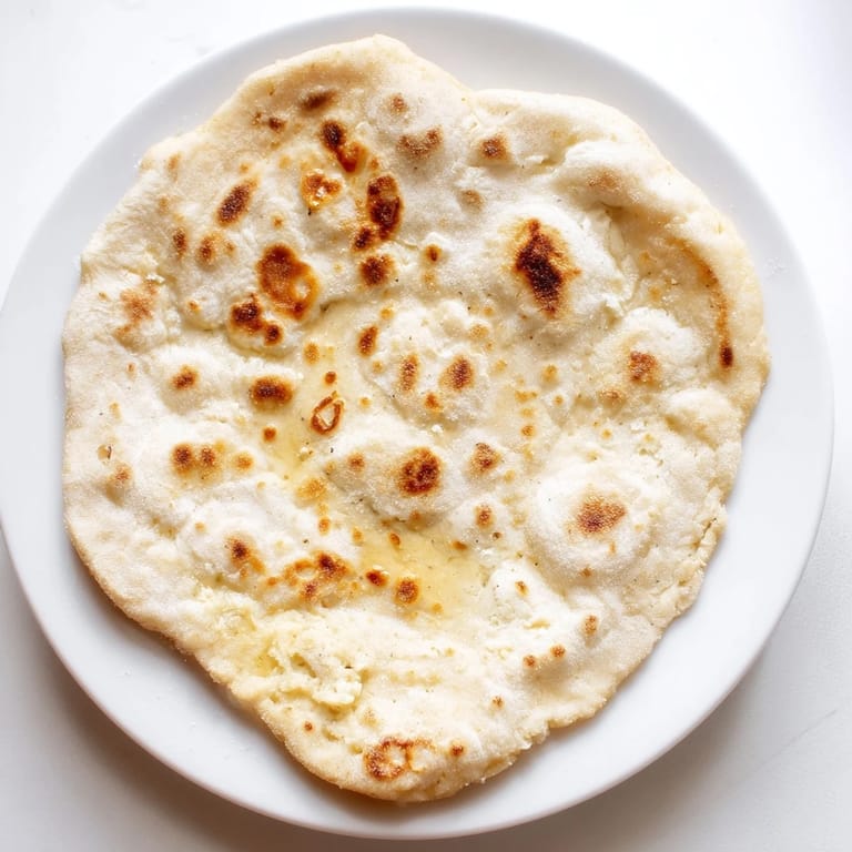 A stack of soft cottage cheese flatbread, perfect for dipping, with slightly charred edges and a tender texture.